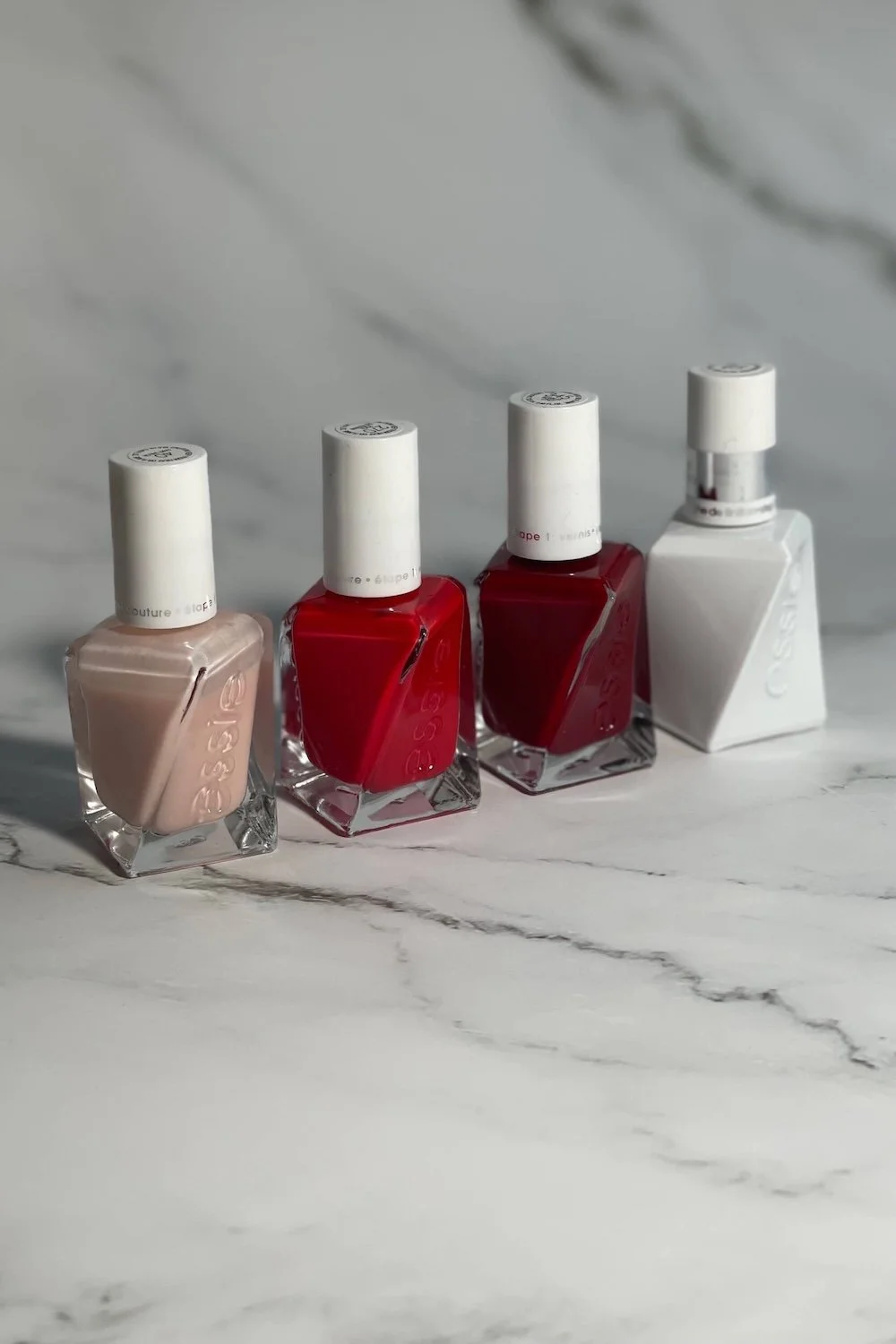 essie gel couture bottles on white marble background