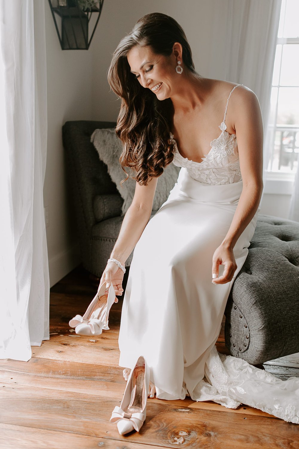 Bride puts on shoes while getting ready for wedding