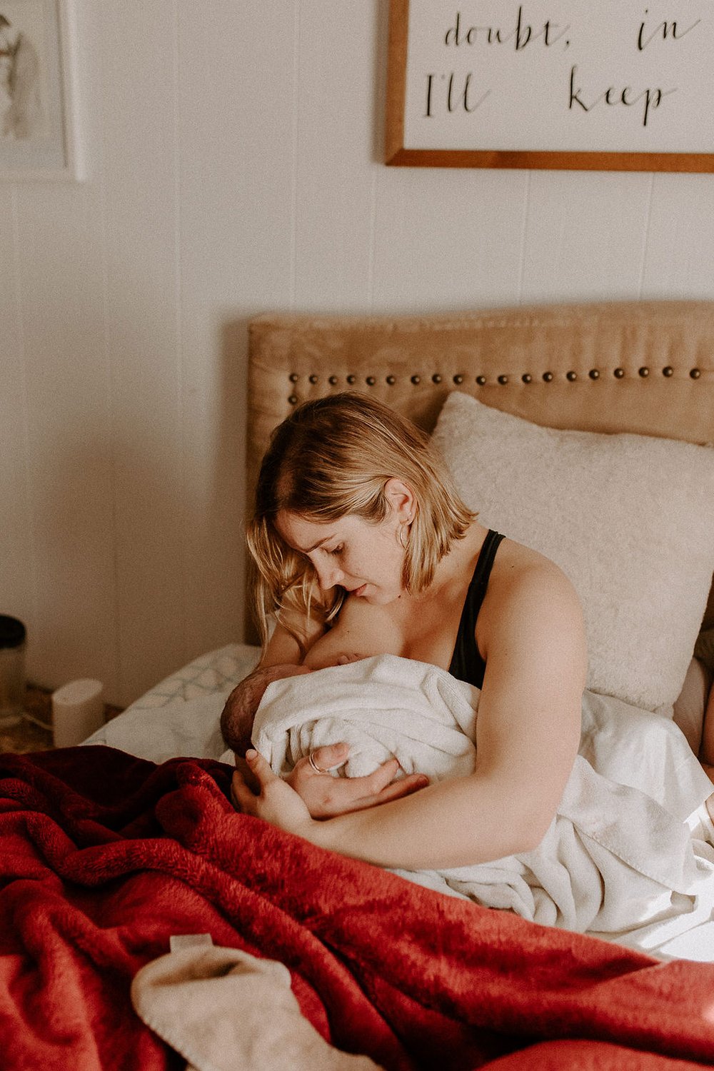 Mom holds newborn in bed following home natural birth