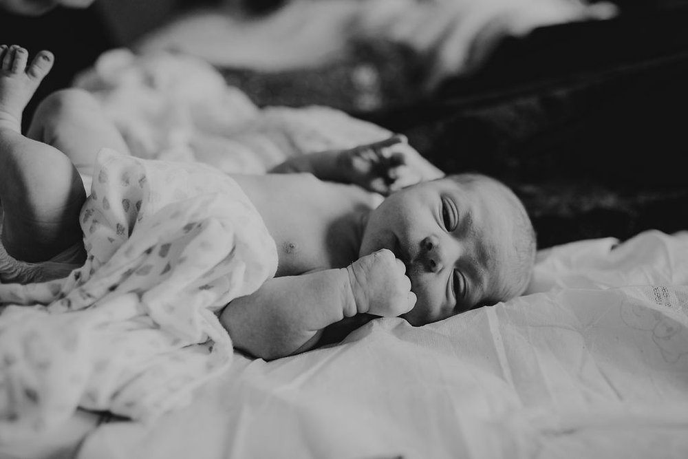 Baby lies on bed at lancaster, pennsylvania natural birth