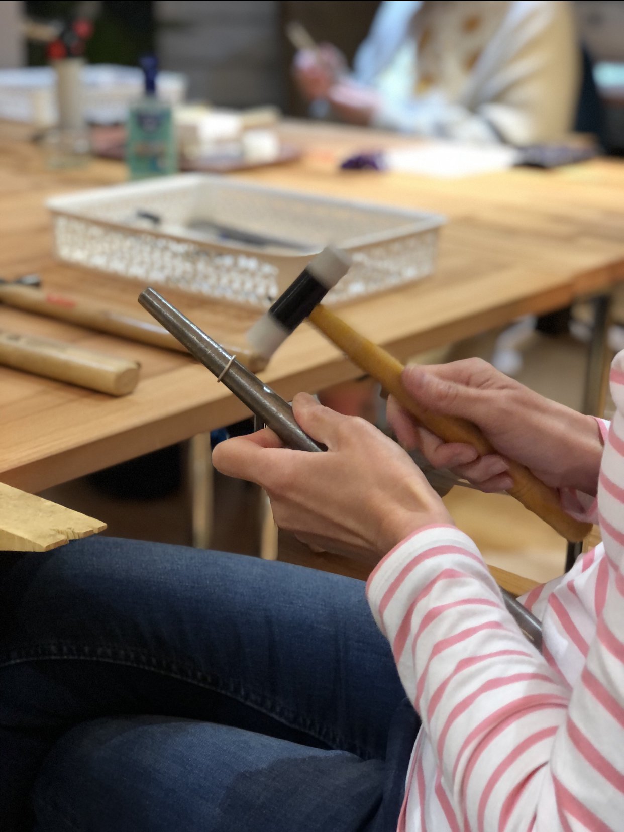 person making a silver ring on a mandrel with mallet at our skinny stacking rings workshop