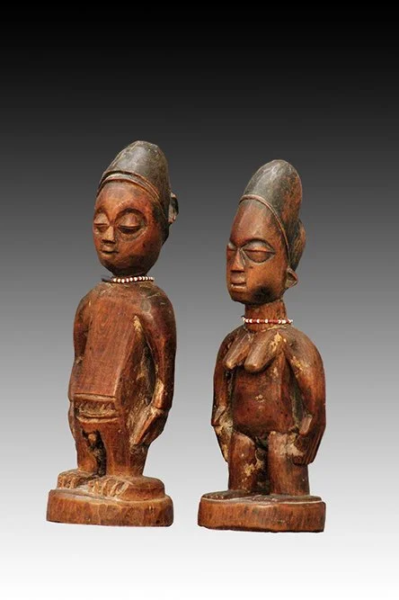 Yoruba Ibeji twin figures with smooth surface and light brown patina.  www.intriguegallery.com