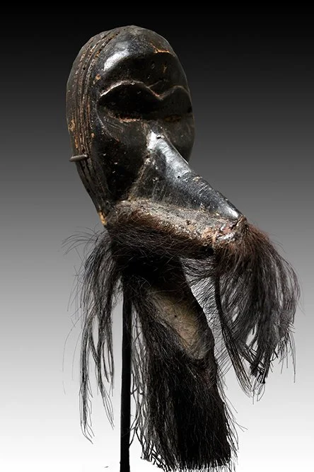 Dan Gagon miniature mask has slit eyes, a large beak or snout, the lower jaw is moveable.  www.intriguegallery.com