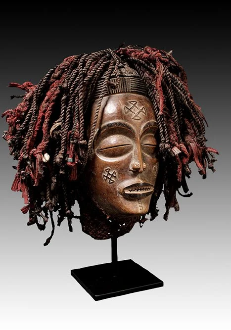 Chokwe mask with arched brows, half closed eyes, linear nose and mouth baring teeth.  www.intriguegallery.com
