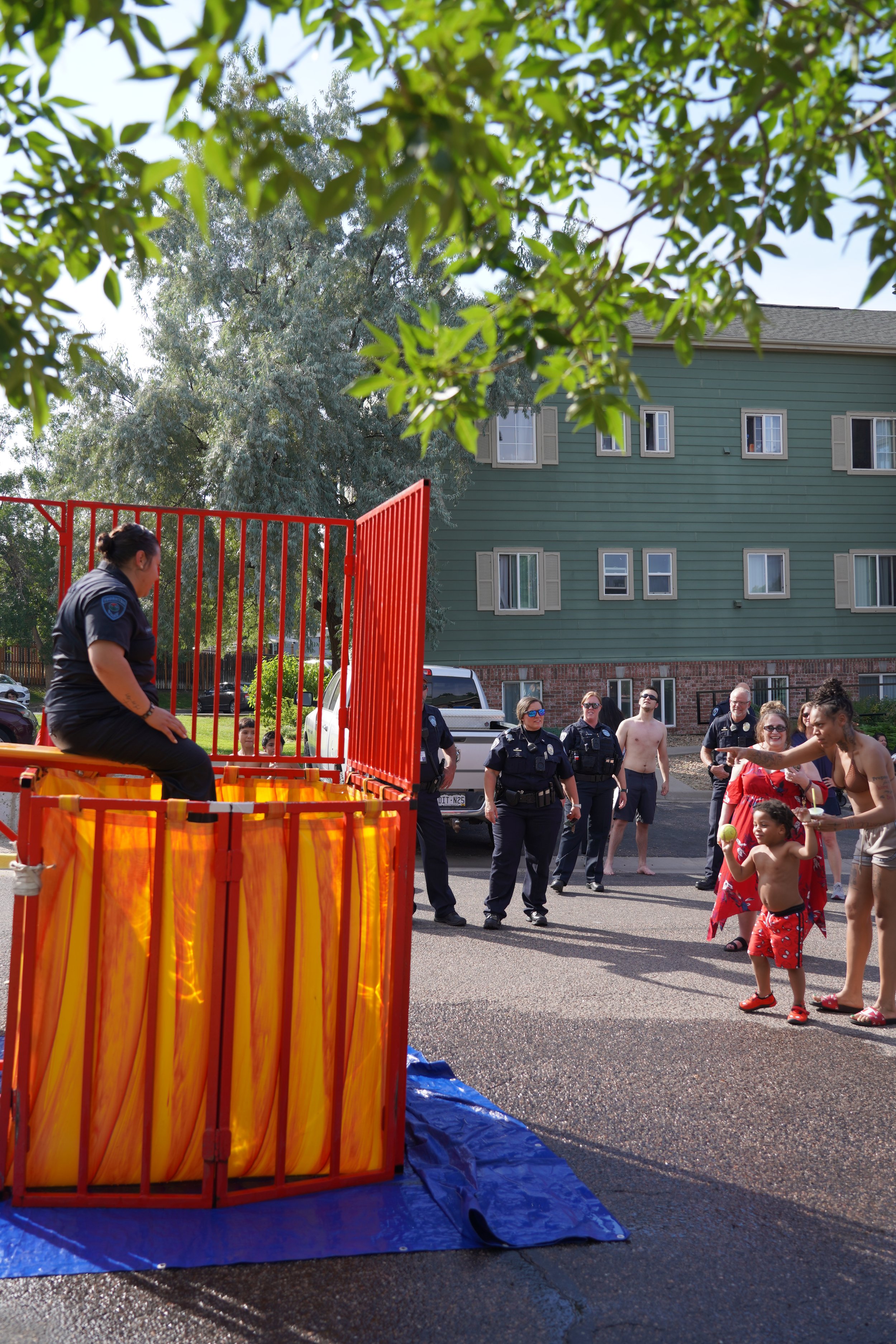 police officer sitting on dunk tank ledge