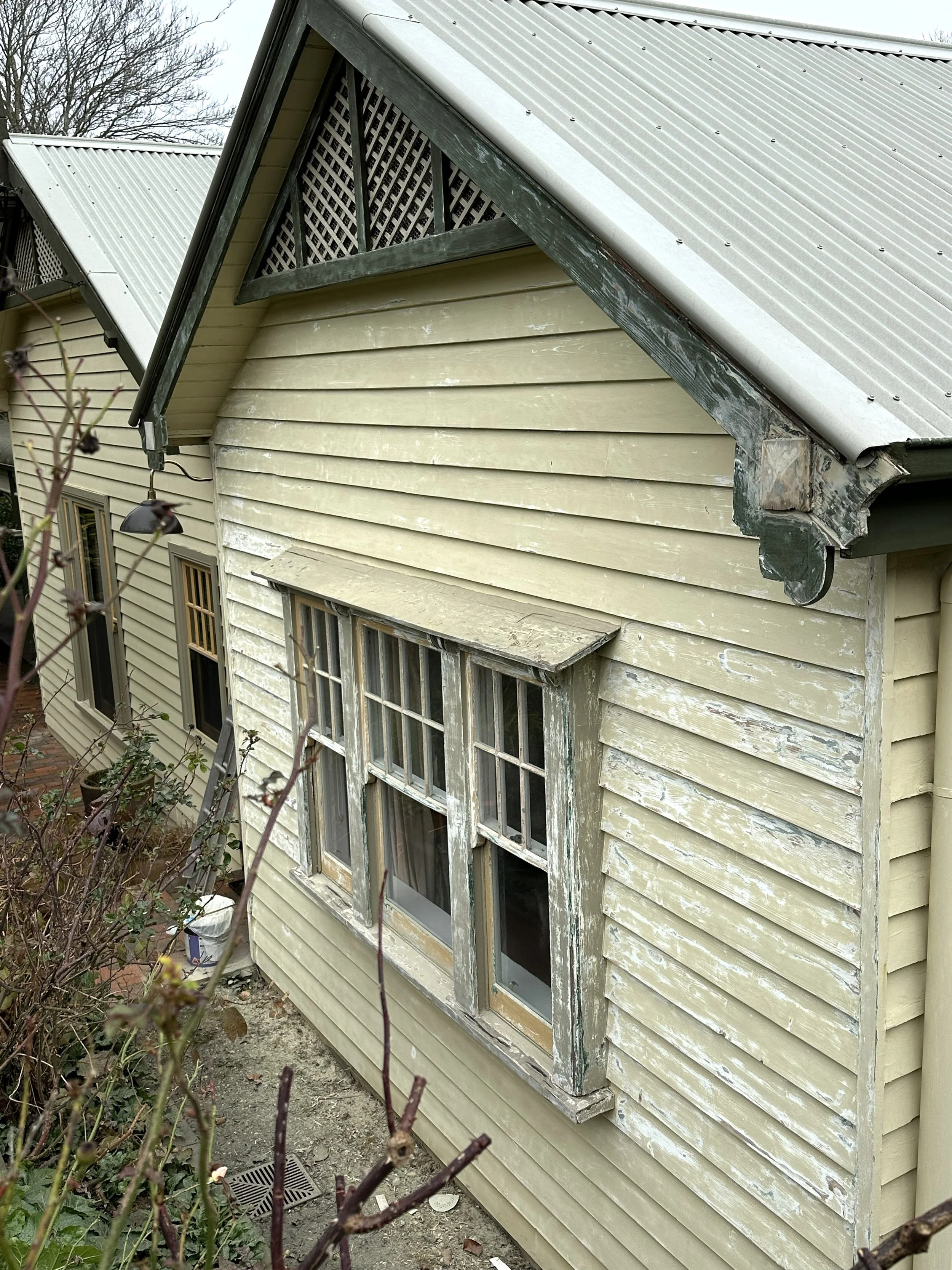 Before photo of sash window with cracked putty and worn timber needing restoration.