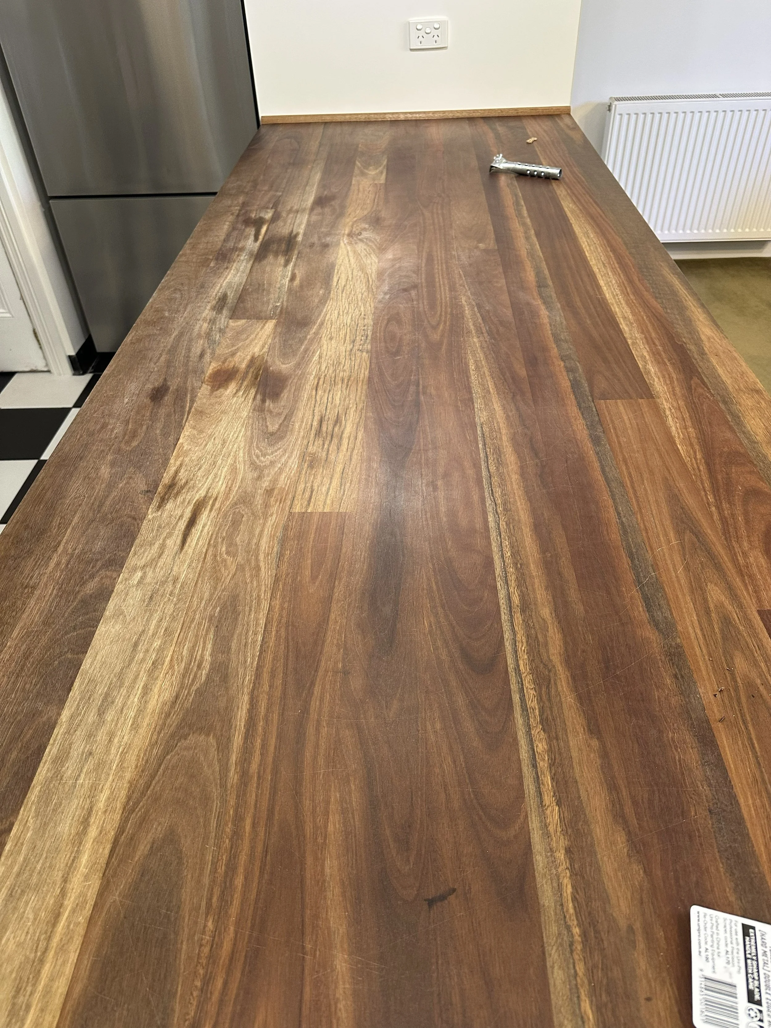 Before photo of benchtop with worn coating and surface damage.