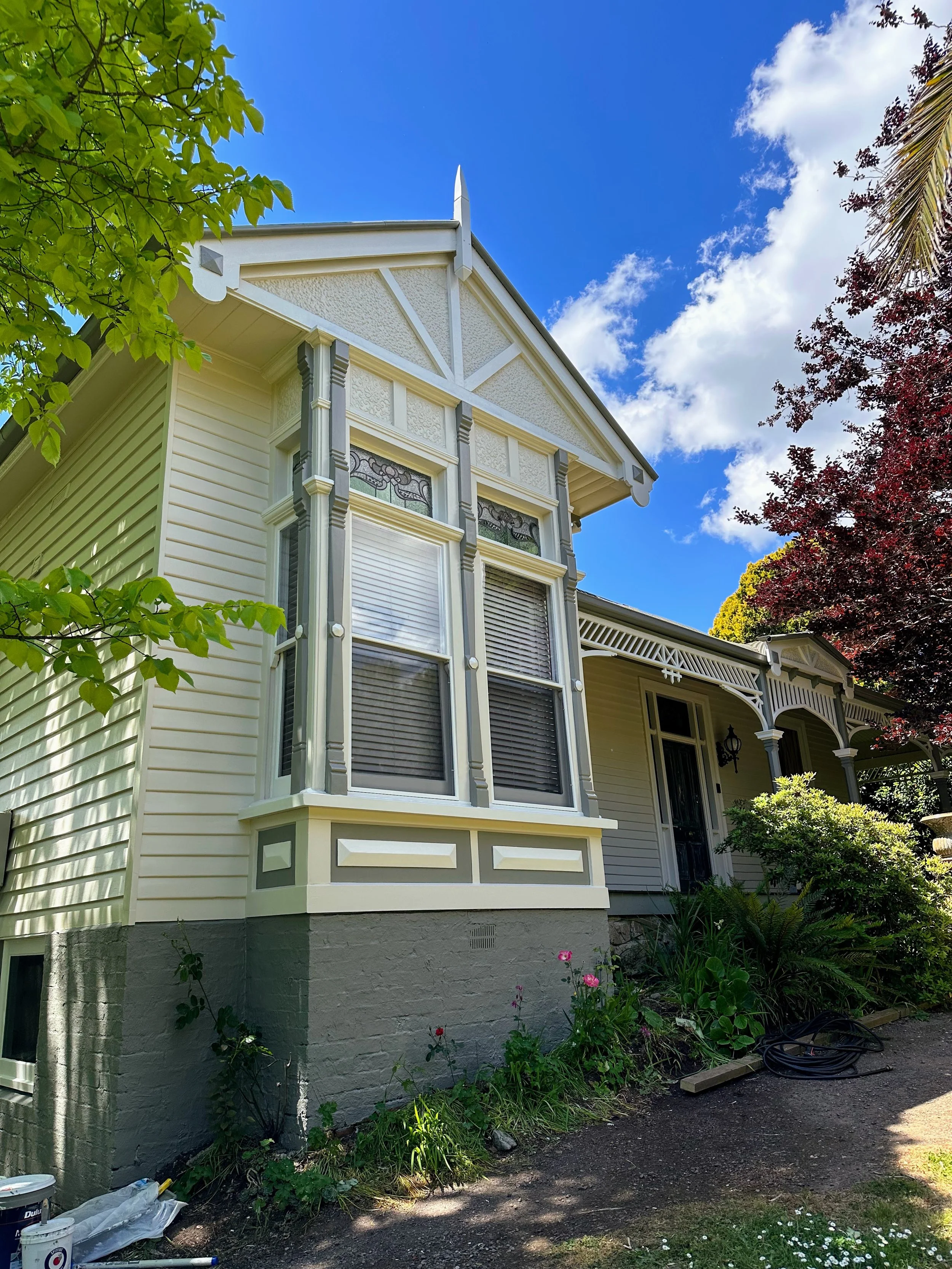Victorian‑style weatherboard home with detailed exterior trim after professional preparation and repainting