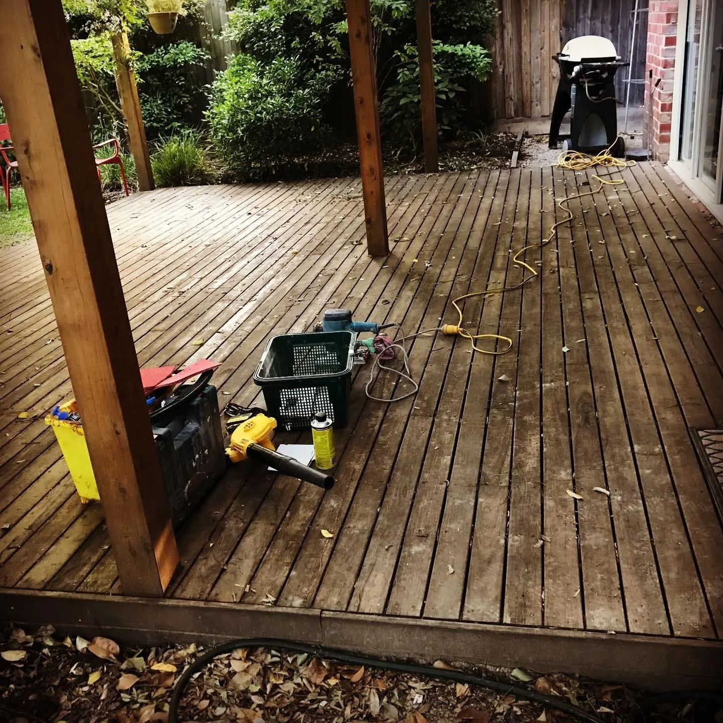 Before photo of deck with faded timber and weathered boards.