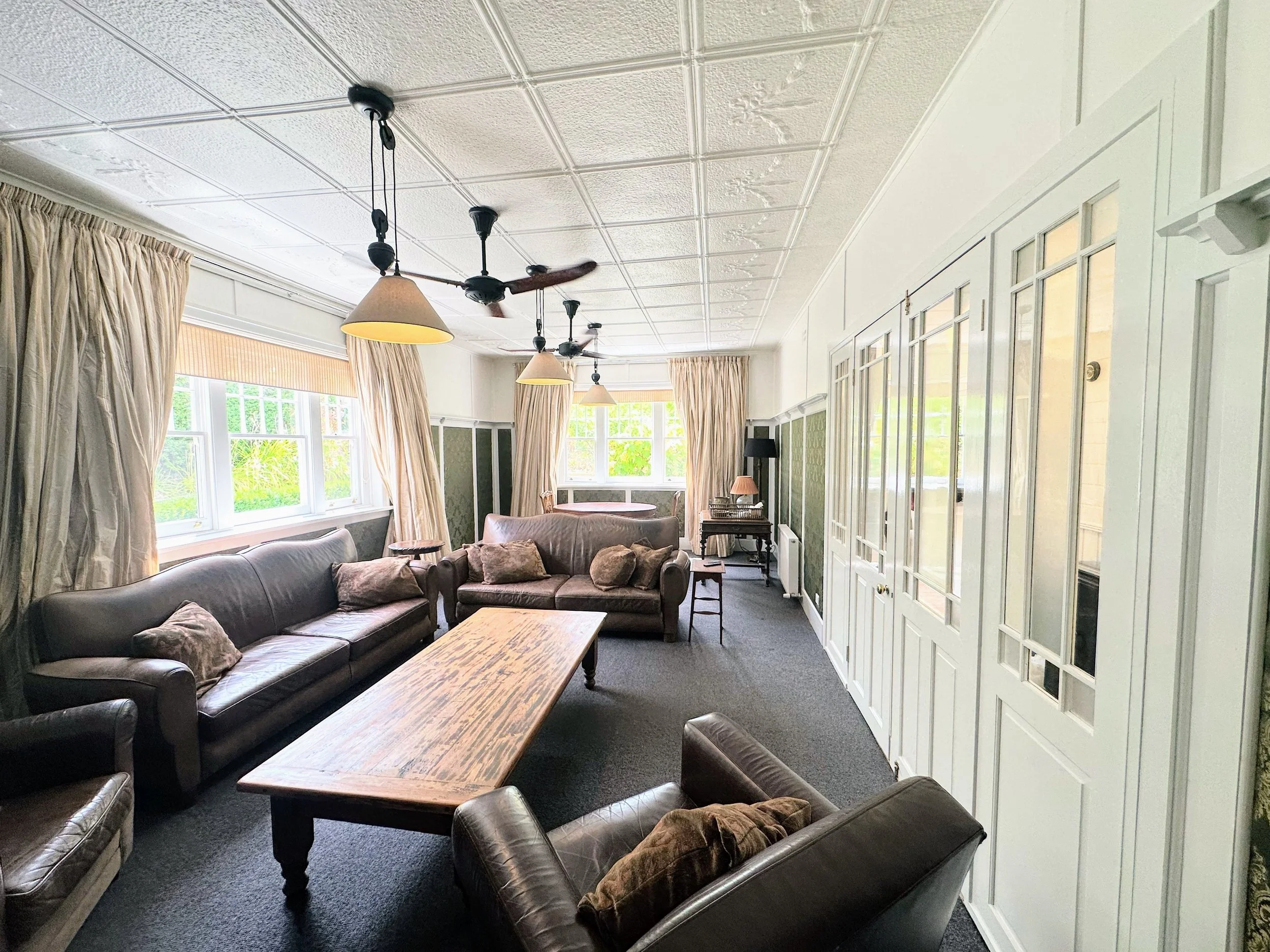 Freshly painted living room with smooth walls, crisp cutting‑in, and restored timber trims.