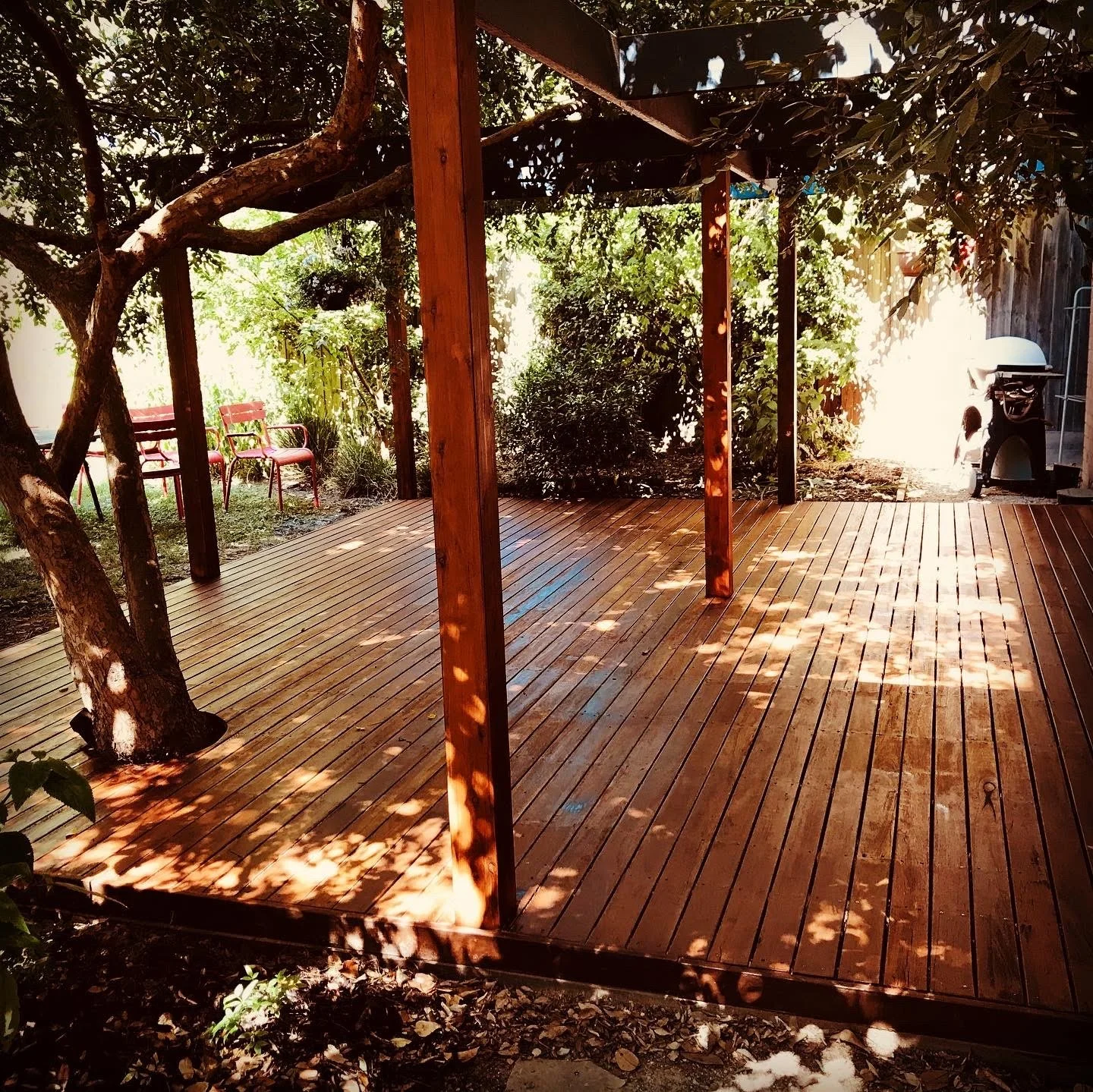 After photo showing restored deck with sanded boards and fresh protective coating.