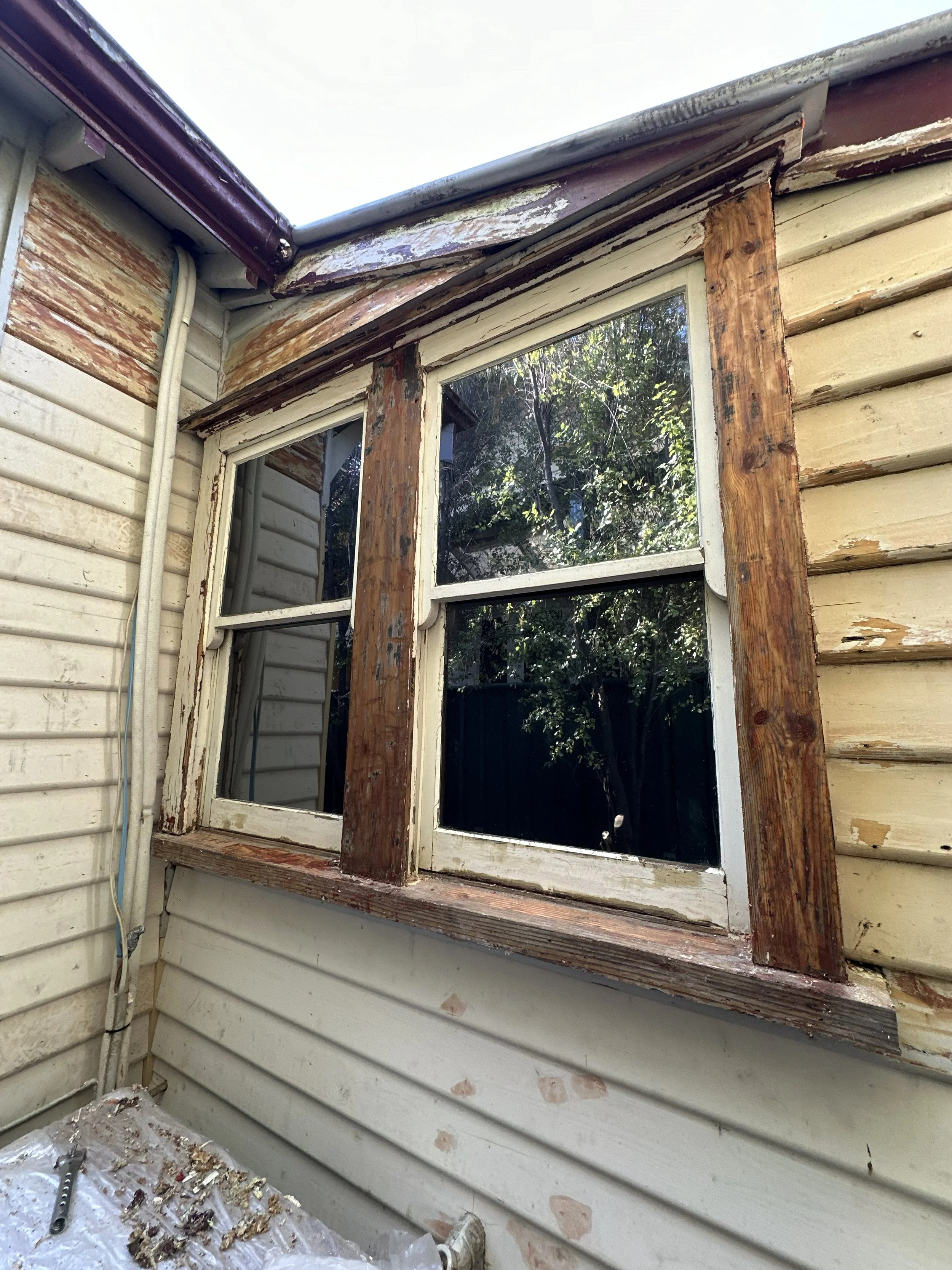 Before photo of sash window with peeling paint and damaged putty.