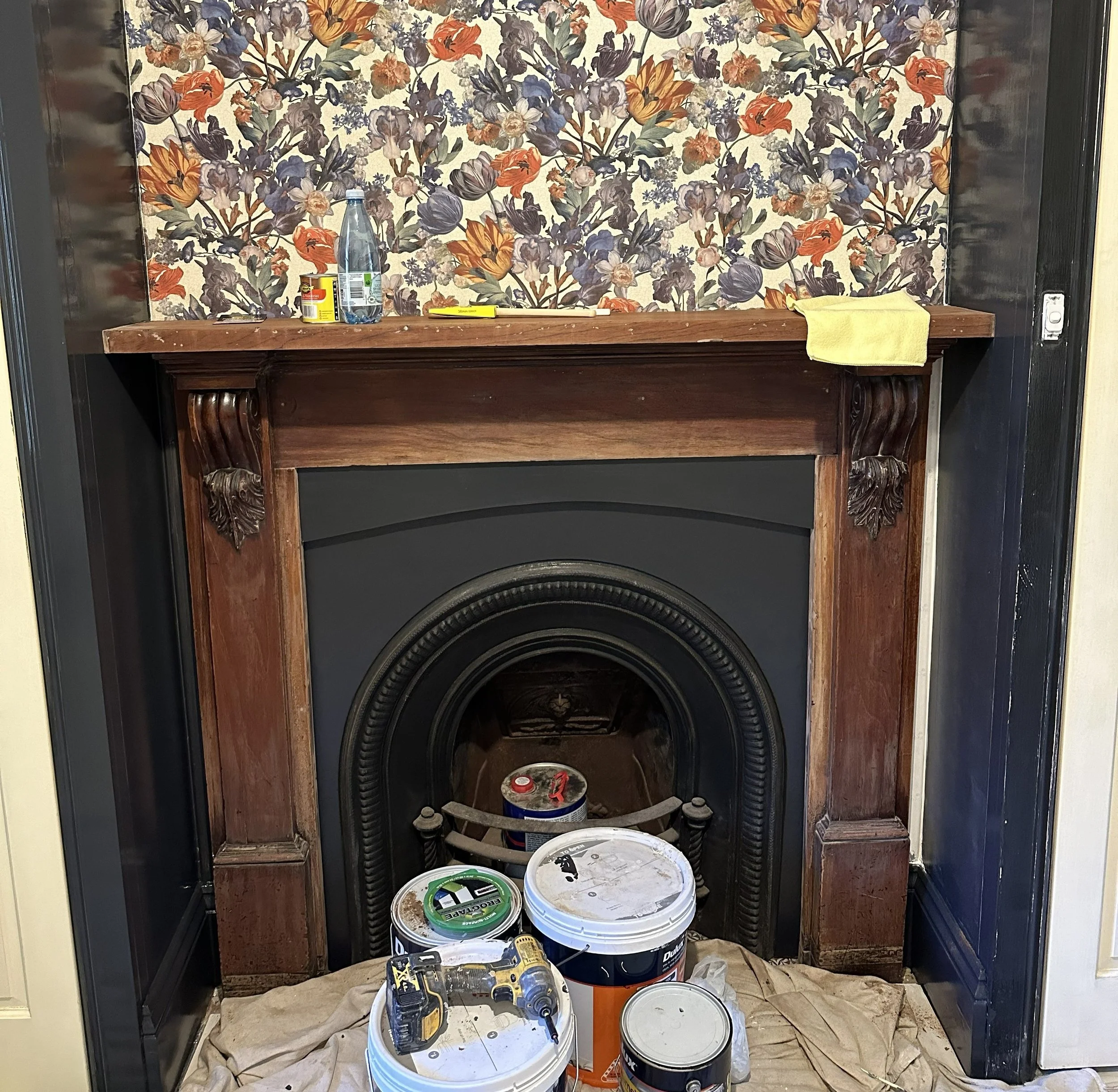 Before photo of fireplace surround with chipped paint and aged timber