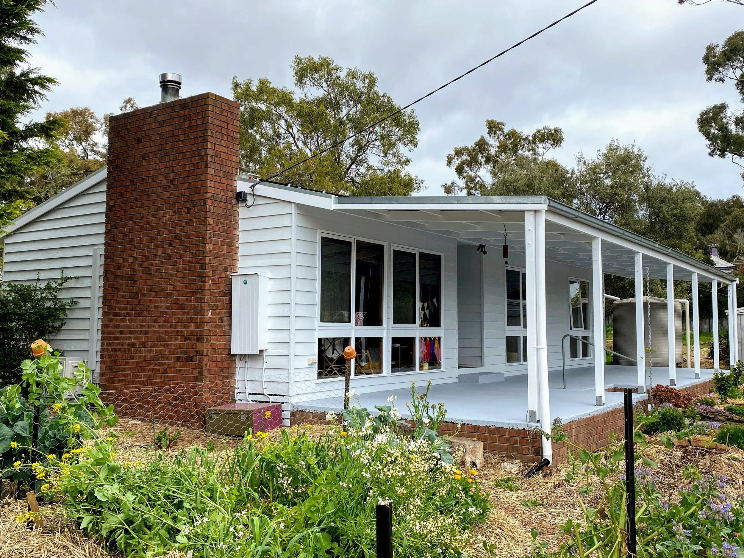 Fresh exterior repaint on a weatherboard home showing smooth finish and restored timber surfaces.
