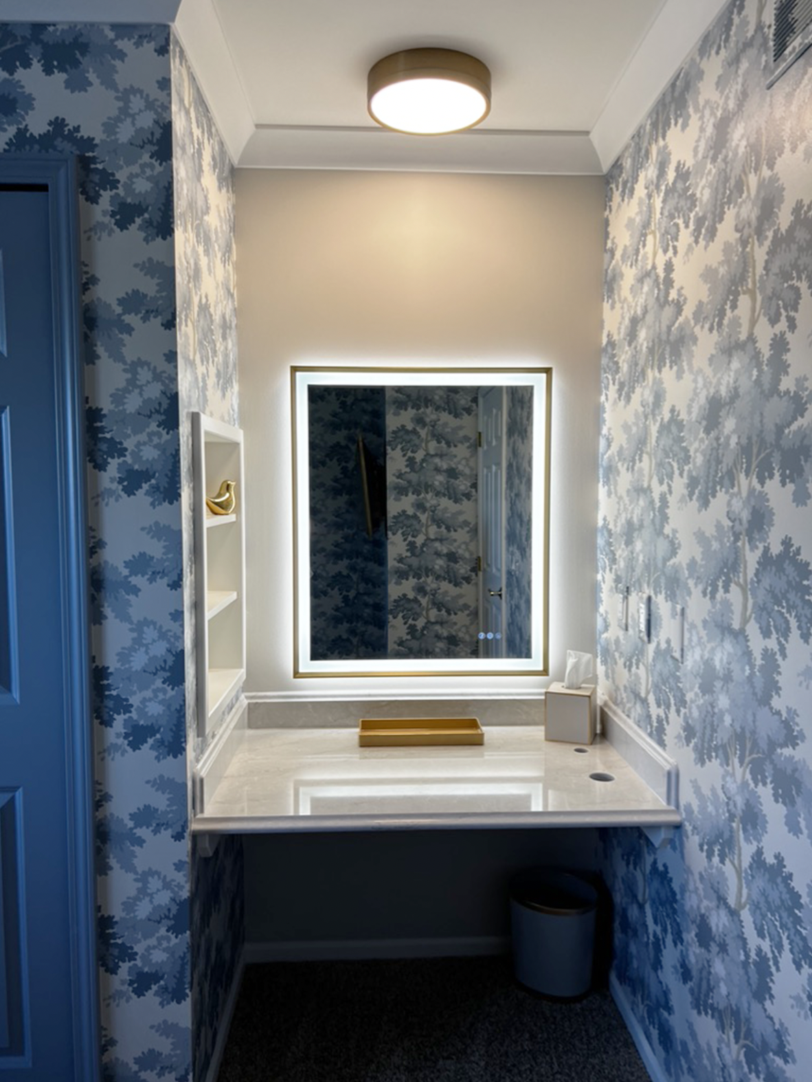 custom built in quartz vanity with specialty edge profile, and holes for hair dryer & curling iron. back and front-lit mirror with built-in niche for cosmetic storage