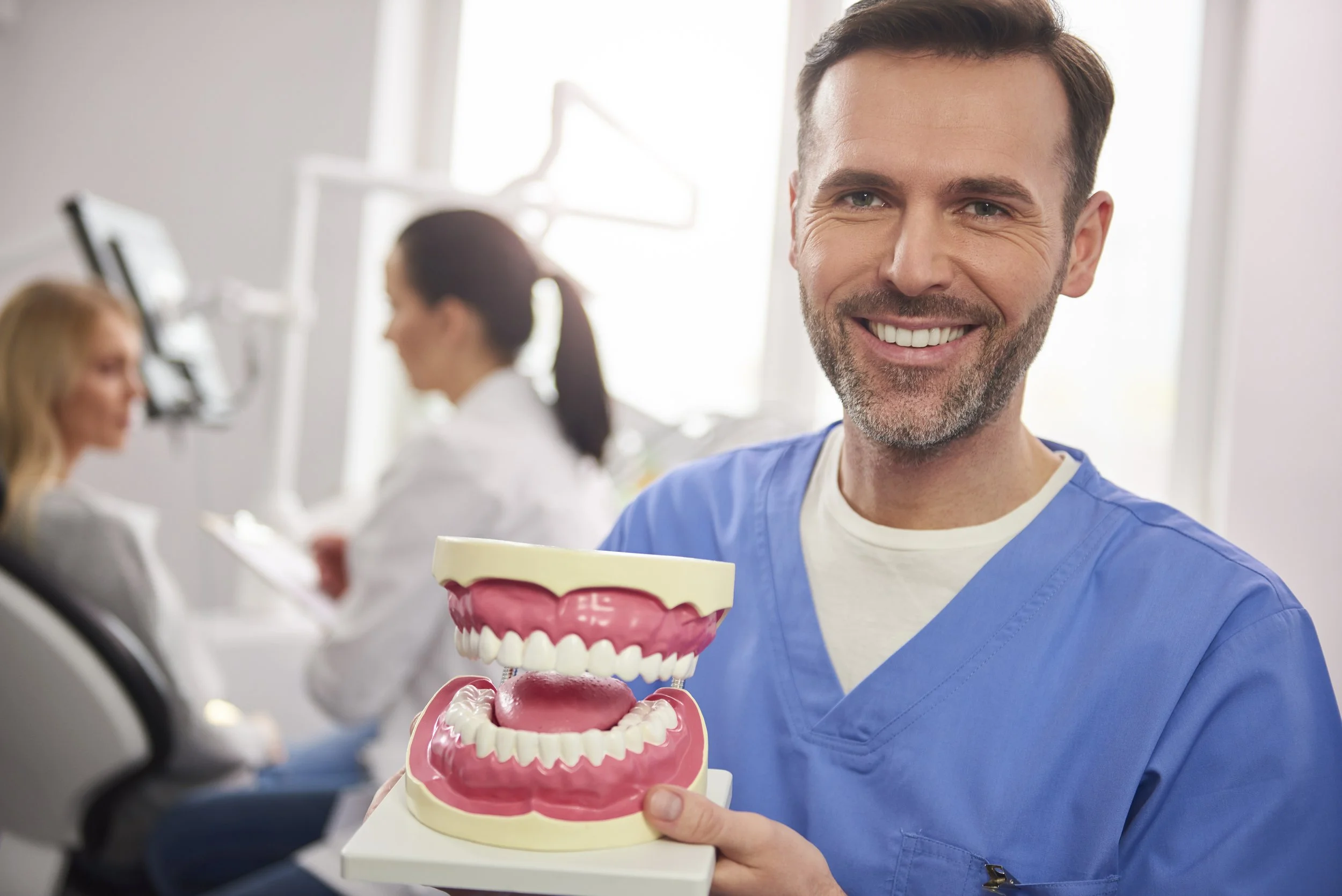 smiling-dentist-showing-artificial-dentures.jpg
