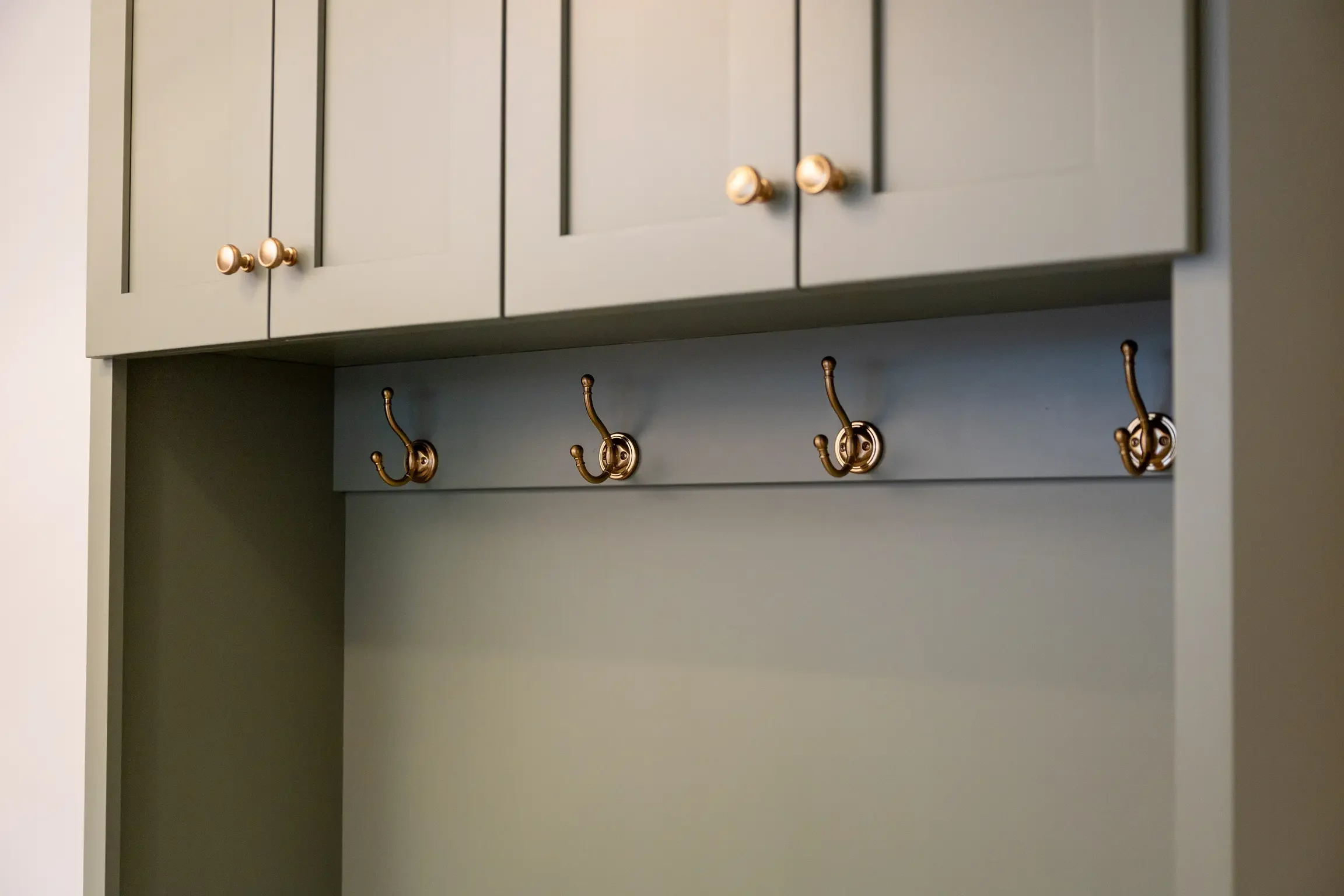Custom mudroom storage lockers in Columbus, Ohio featuring built-in cabinetry, brass hardware, integrated coat hooks, and functional family storage solutions by Elevate Remodeling.