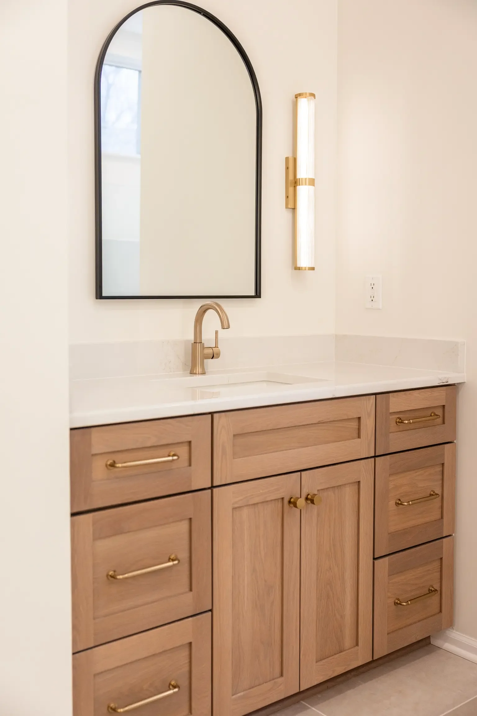 A custom white oak vanity that anchors the whole room — natural warmth paired with clean, modern lines.