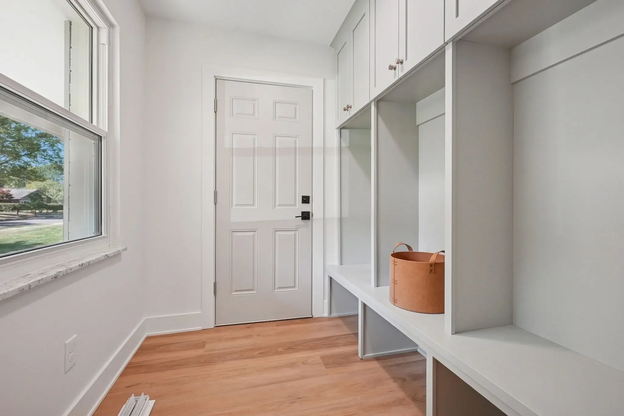 Custom mudroom remodel in Columbus featuring built-in bench seating, storage cabinetry, and hardwood flooring
