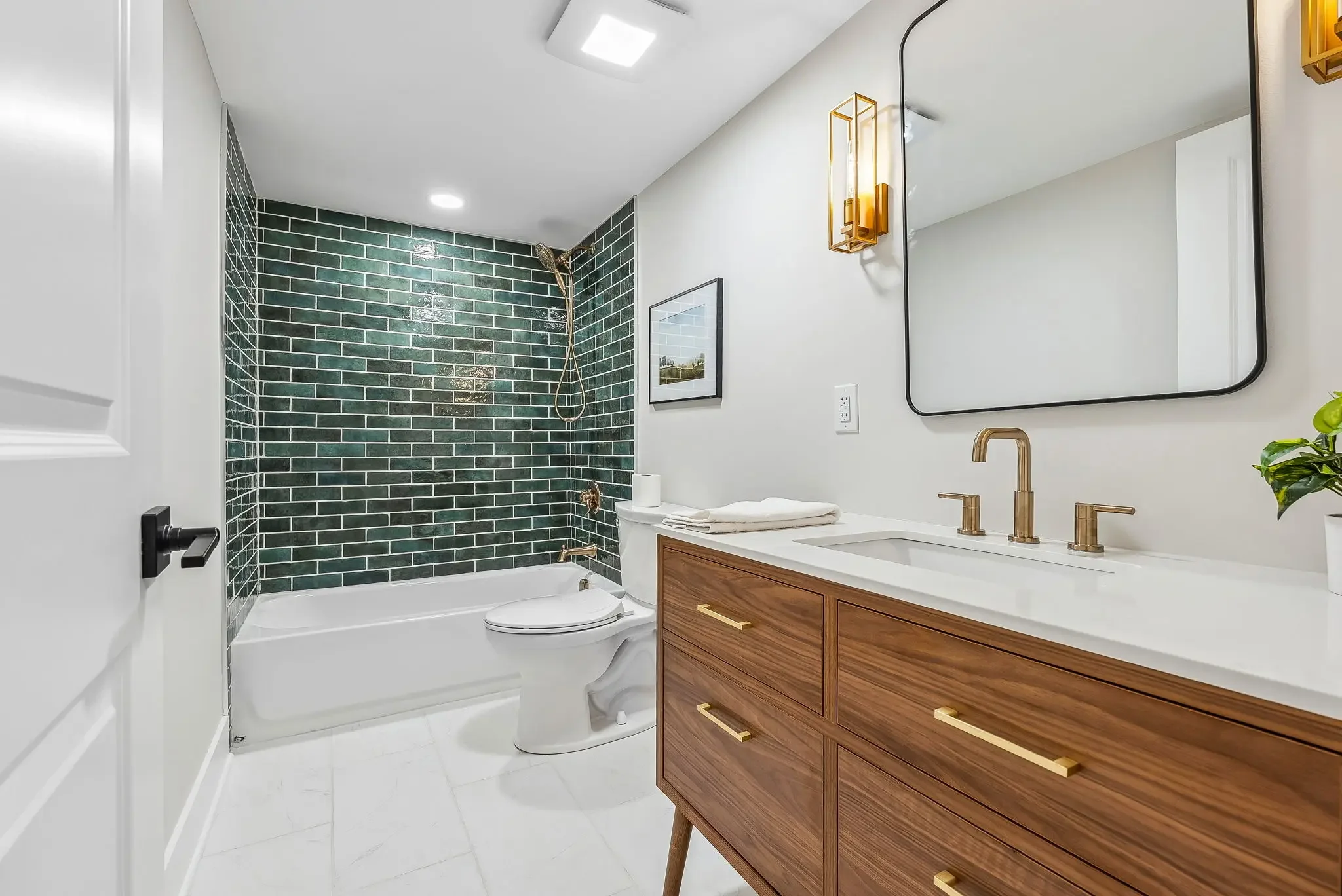Bathroom featuring green subway tile, large format tile floors, modern teak vanity and brass finishes