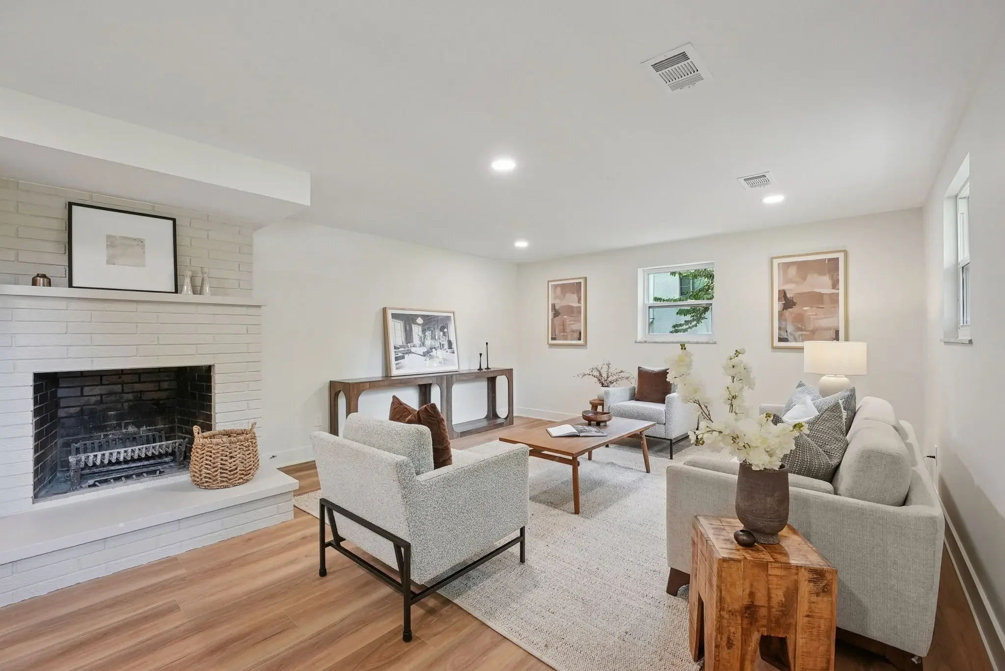 Split level remodel in Upper Arlington, Ohio featuring updated basement living space, painted brick fireplace, modern finishes, improved lighting, and custom home renovation by Elevate Remodeling.