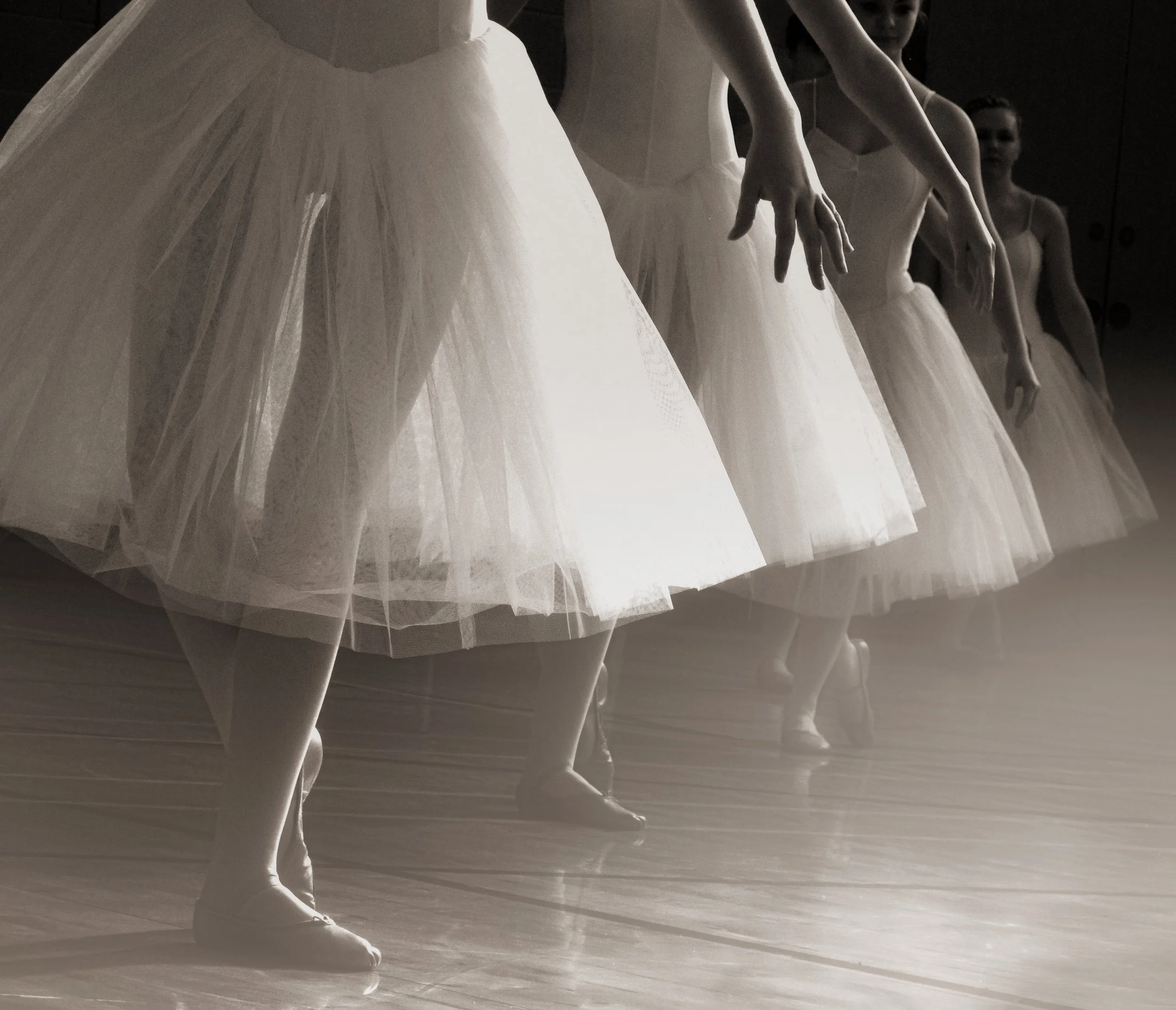 Ballet dancers in tutus practicing on stage