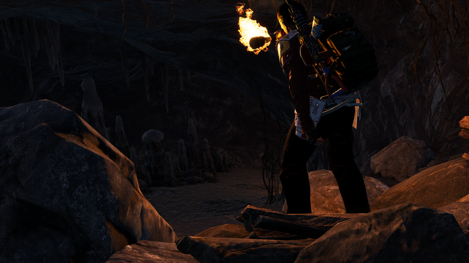 Player exploring a torch-lit cave interior in Rust Console Edition