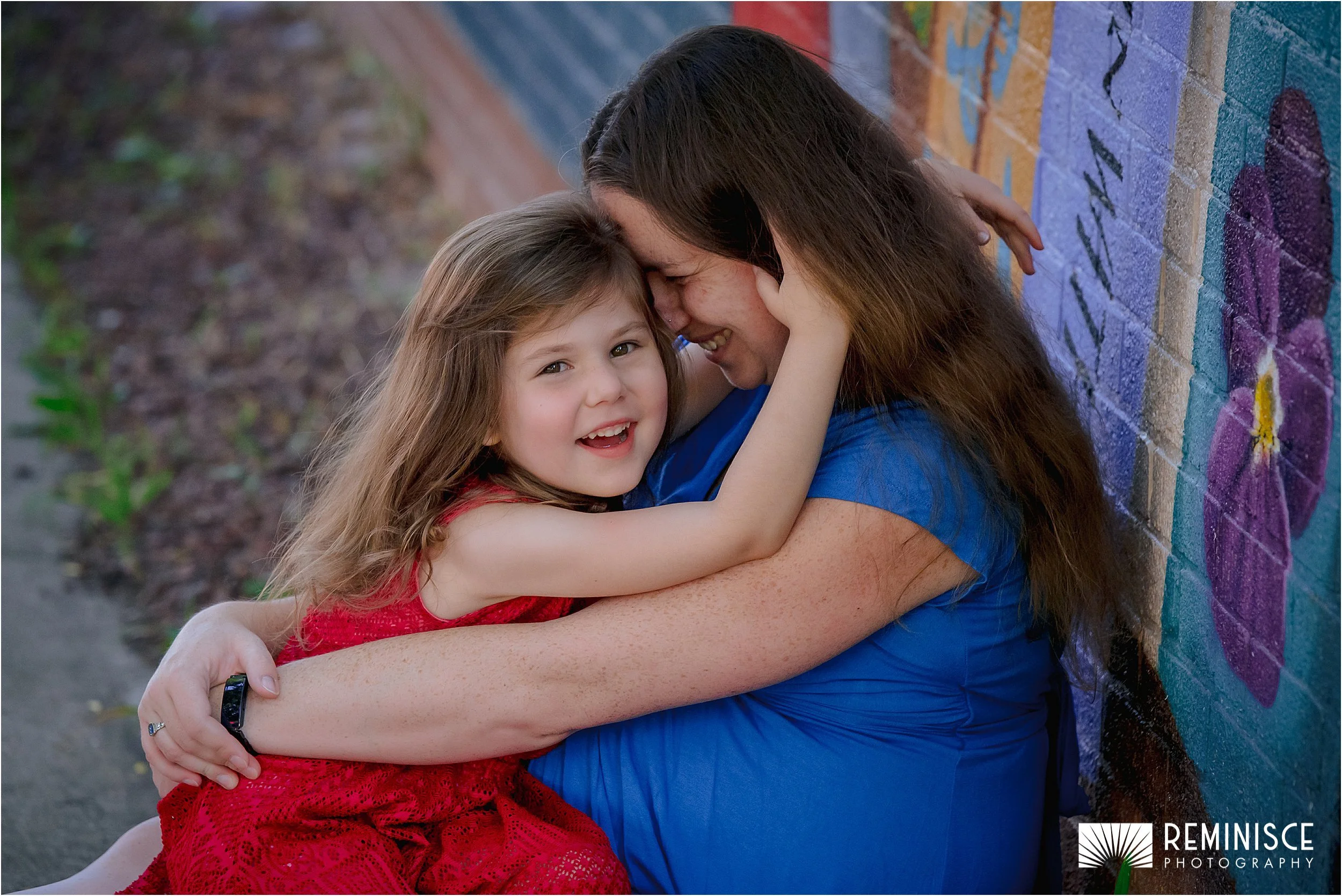 03-girl-touching-mom-face-looking-at-camera-seated-sidewalk.JPG