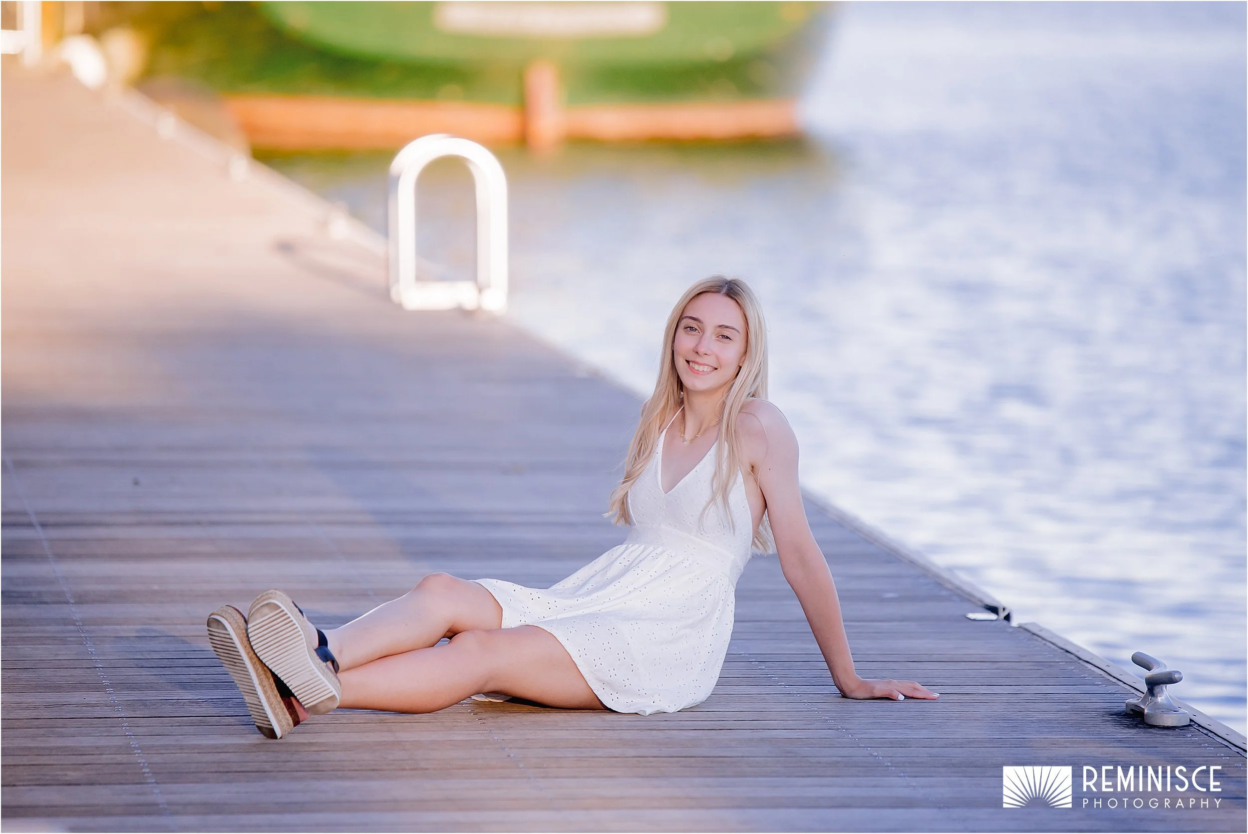 11-girl-seated-legs-out-wooden-modern-dock-blue-water.JPG