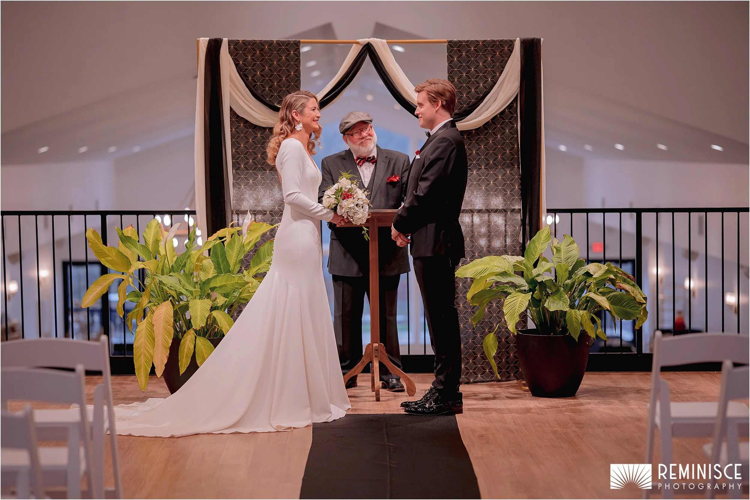 07-bride-groom-exchanging-vows-plants-each-side-black-white-drape.JPG