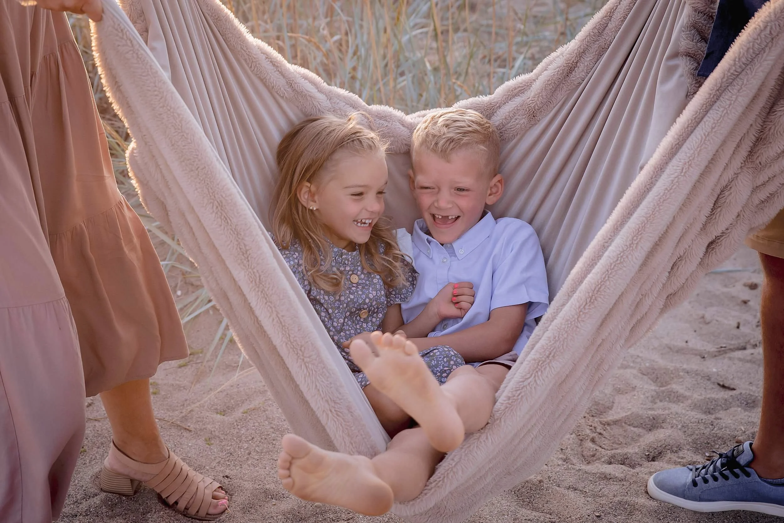 fun-candid-family-photos-siblings-swinging-blanket.png