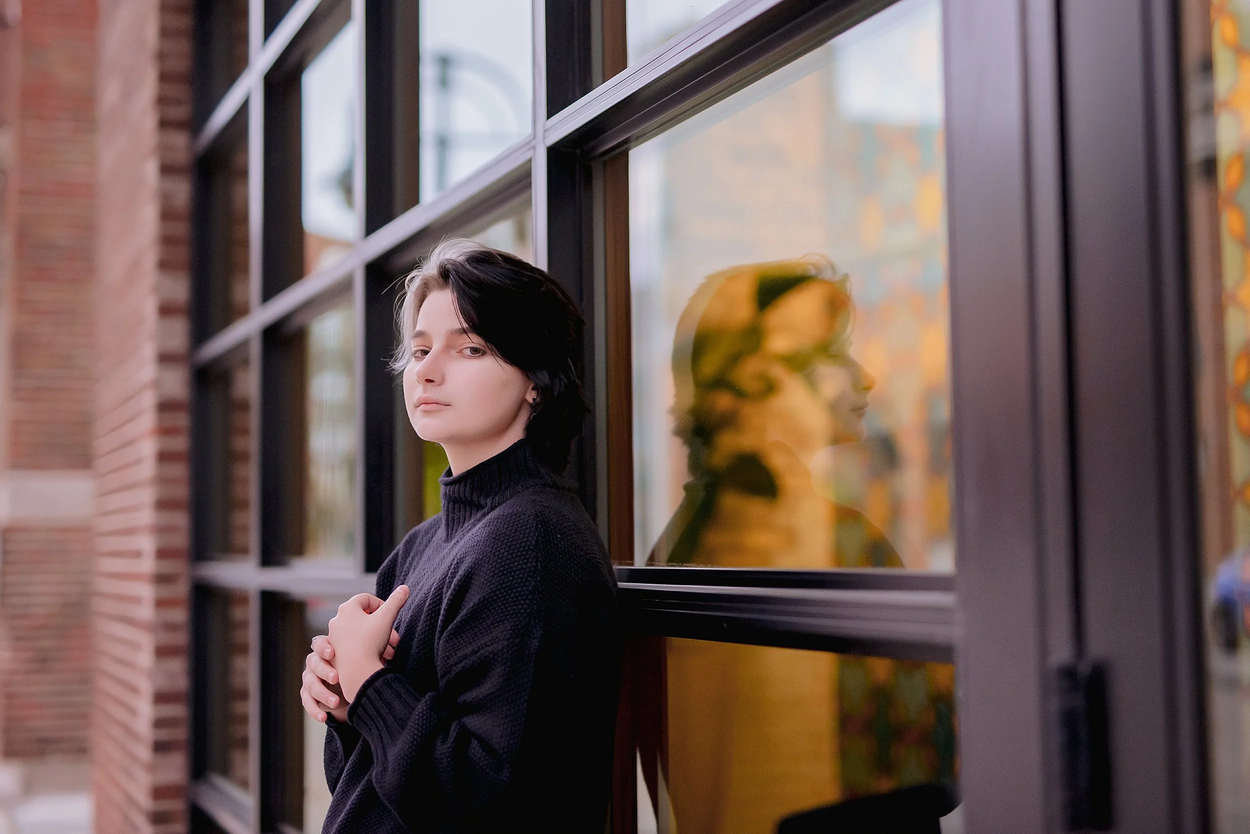 high-school-senior-leaning-back-of-downtown-glass-window.JPG