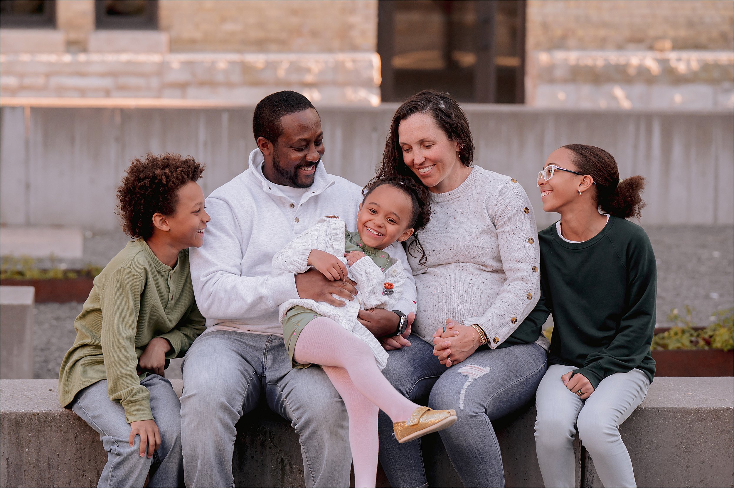 Family laughing together during a Milwaukee family mini session with candid connection and natural expressions