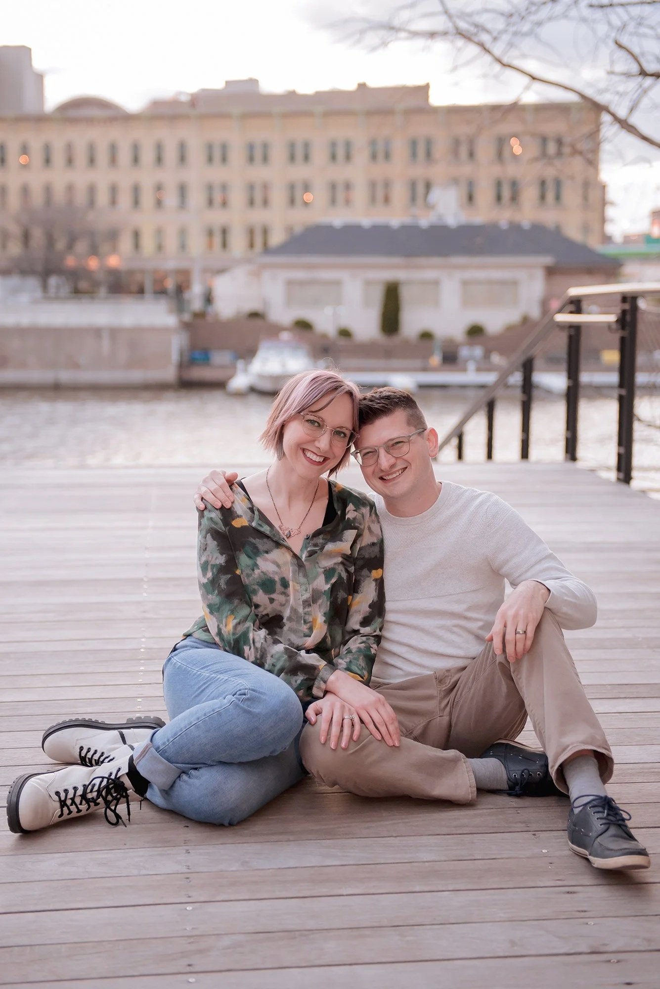 Miranda and Adam of Reminisce Photography sitting on the Milwaukee RiverWalk together in the Third Ward