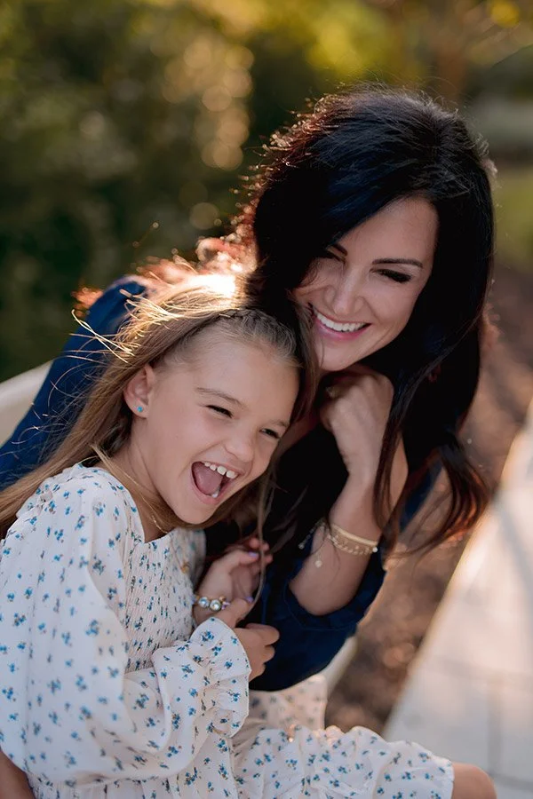 Milwaukee family photographer capturing a candid golden hour portrait of a mother and daughter laughing together outdoors
