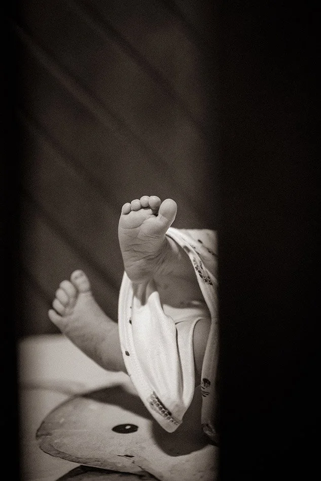 Close-up detail of newborn baby feet in crib during a lifestyle newborn photography session in Milwaukee