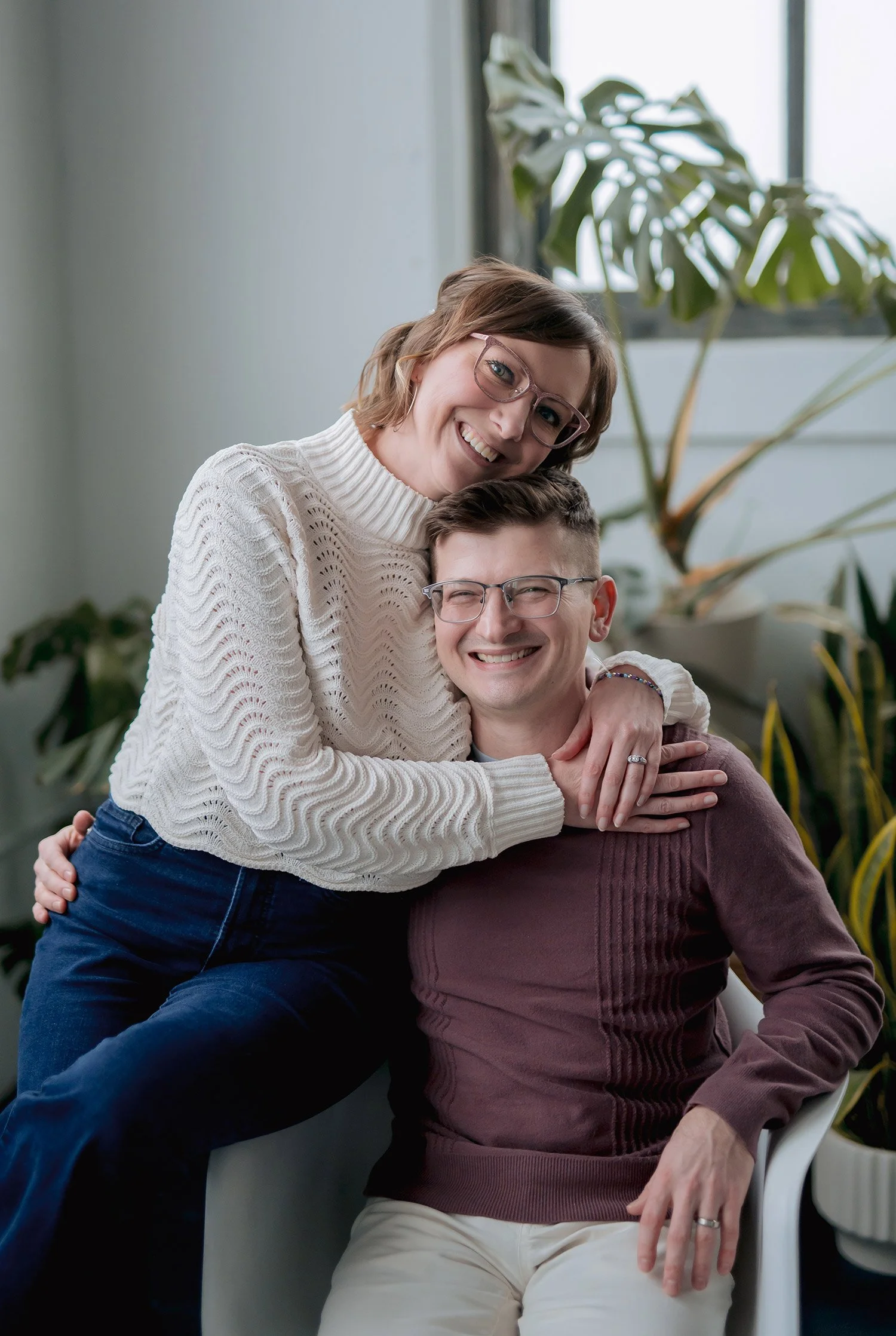 Reminisce photographers Miranda and Adam hugging in Milwaukee studio with plants