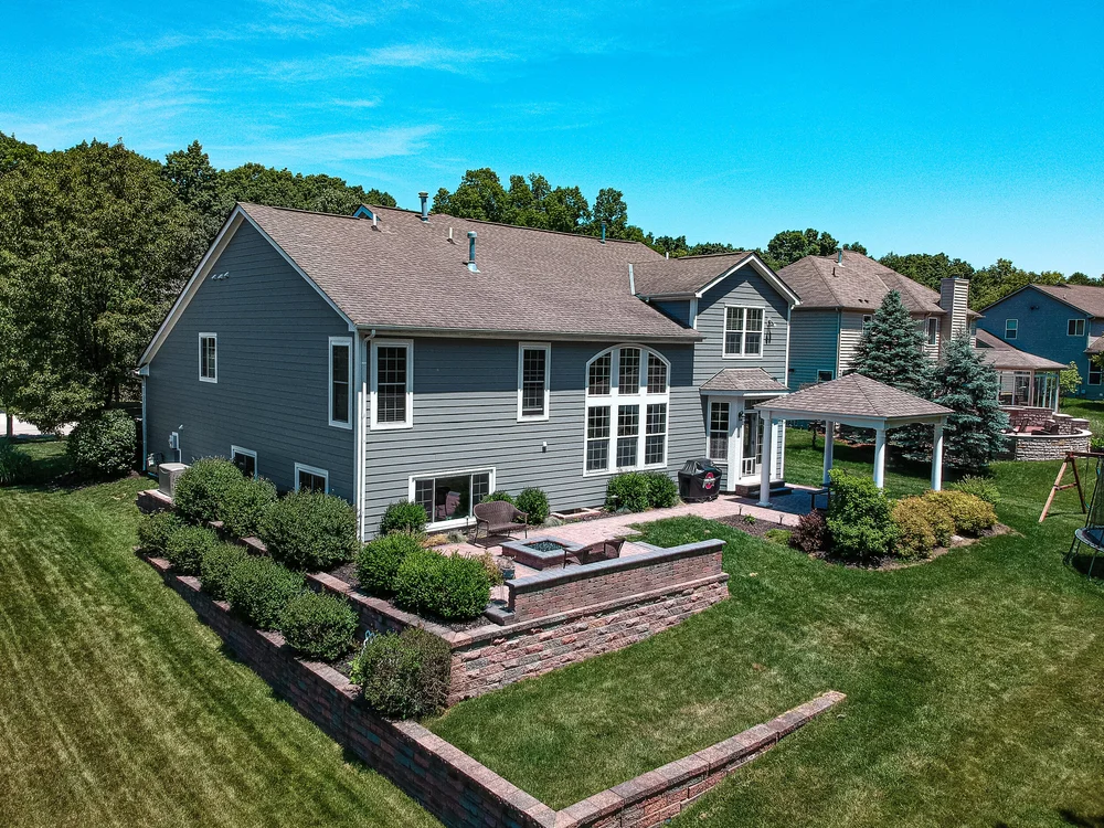 Finished siding on a two-story home with deck and lawn, aerial photo in Columbus, Ohio