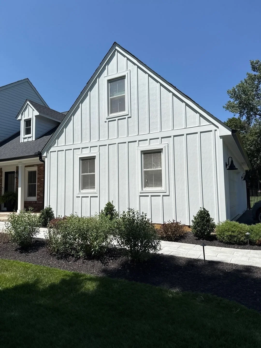 Ground-level view of a white James Hardie board and batten gable beside lap siding on the main house in Dublin