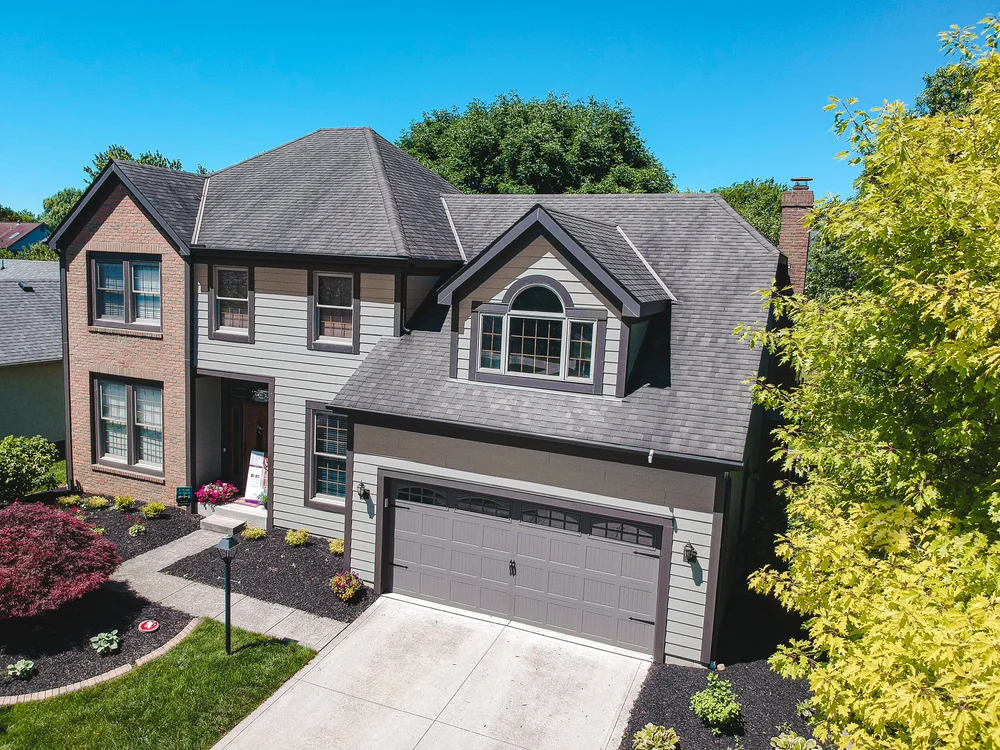 Two-story home with new siding and dormer windows, completed by RoofNut