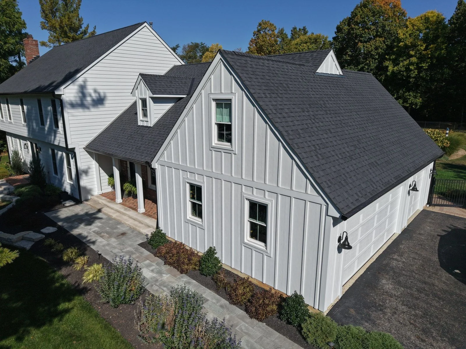 New charcoal shingle roof and white board-and-batten siding on a Central Ohio home installed by RoofNut