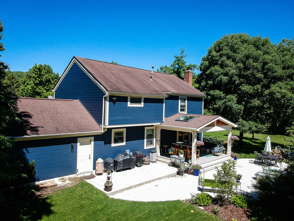 Aerial view of a blue siding home with patio and landscaping in Columbus, Ohio