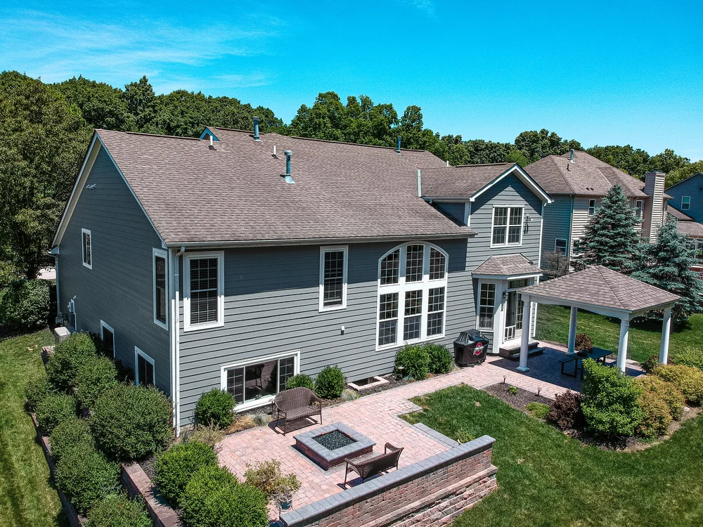 Rear aerial view of a completed siding project with patio and yard in Hilliard, Ohio
