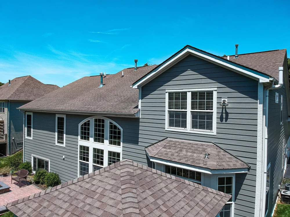 Aerial view of a finished shingle roof and gray siding on a large two-story home in Columbus, Ohio