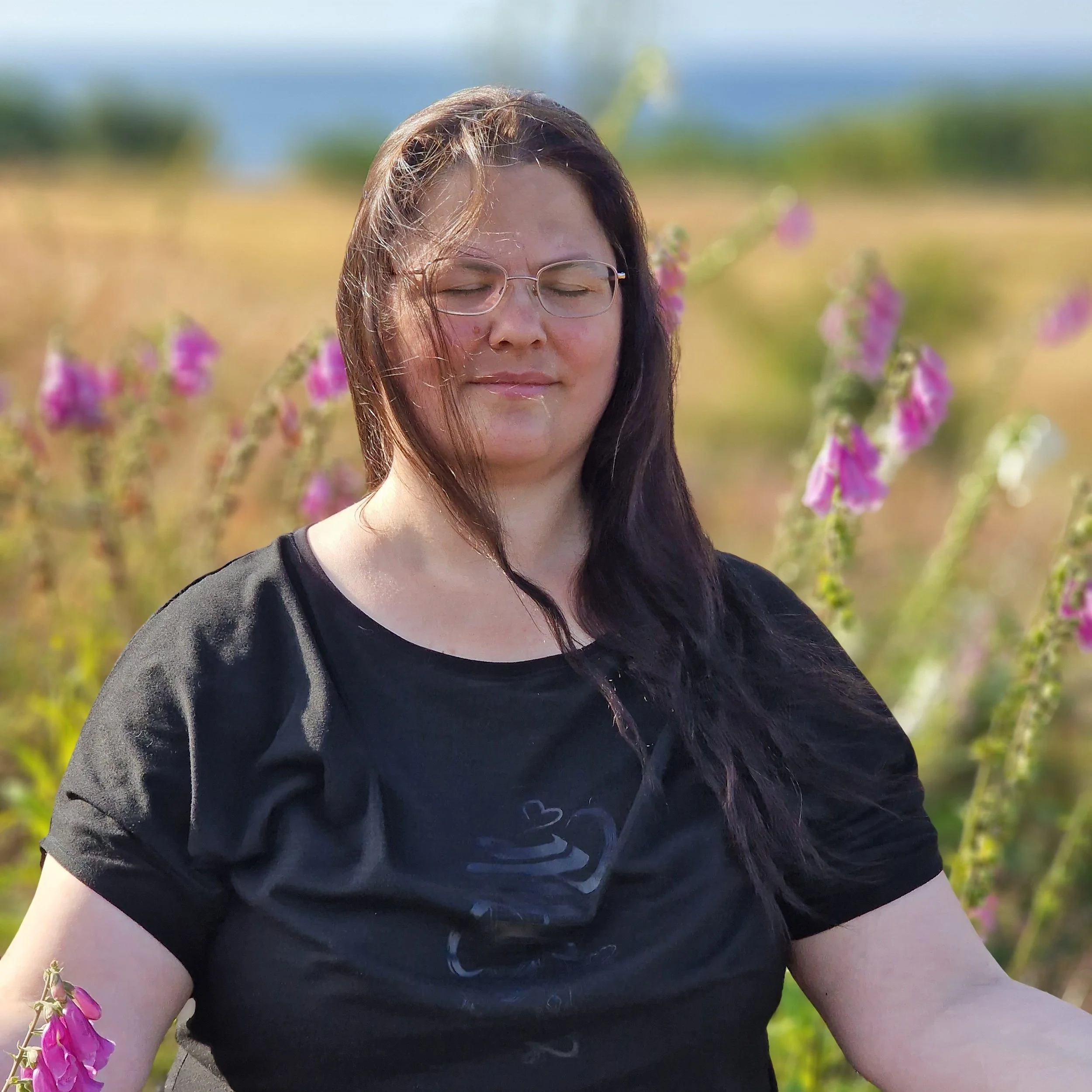 Nina sitter i meditasjon, ute i natur.