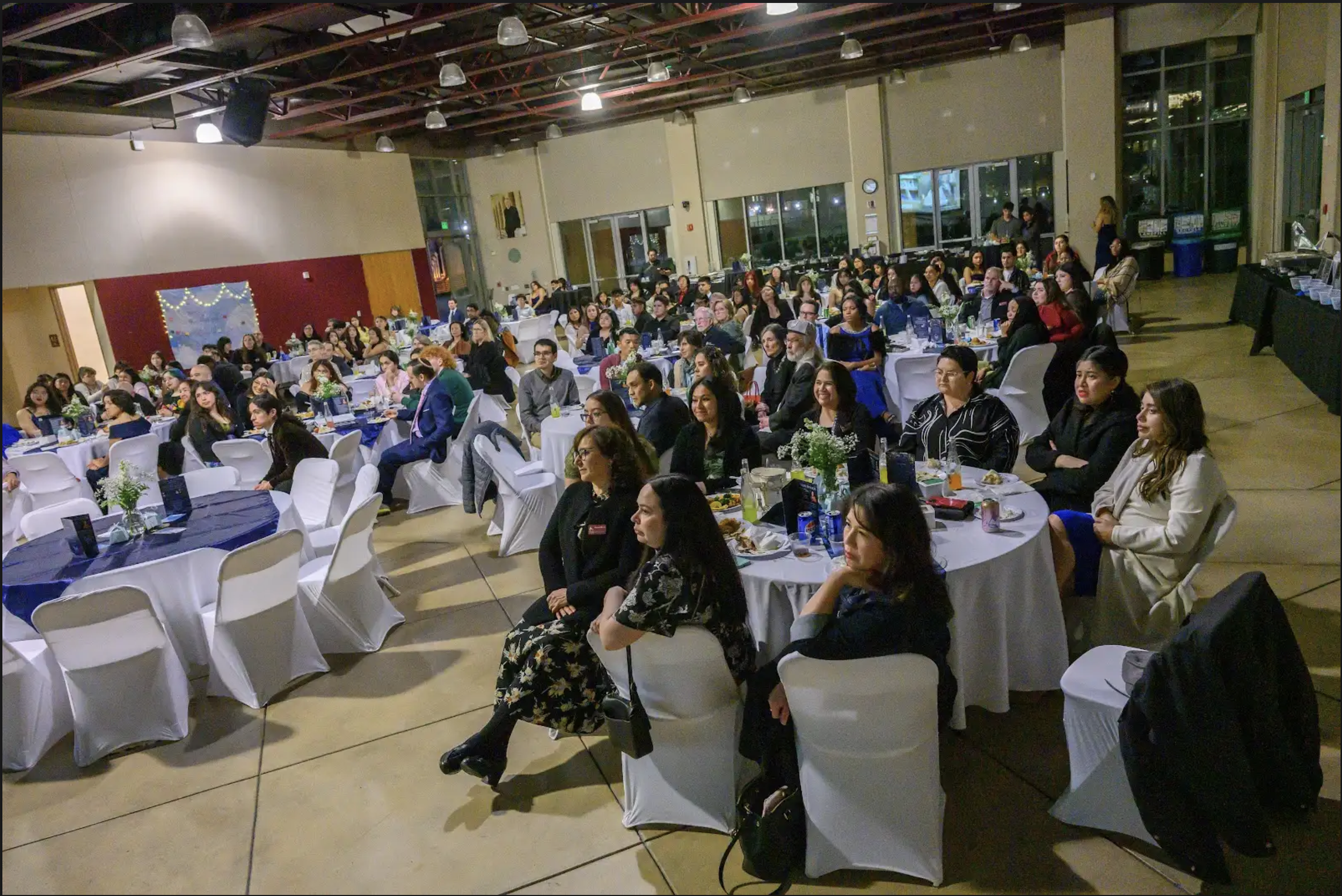 Group of people in Locatelli Event Center sitting in a circular chai
