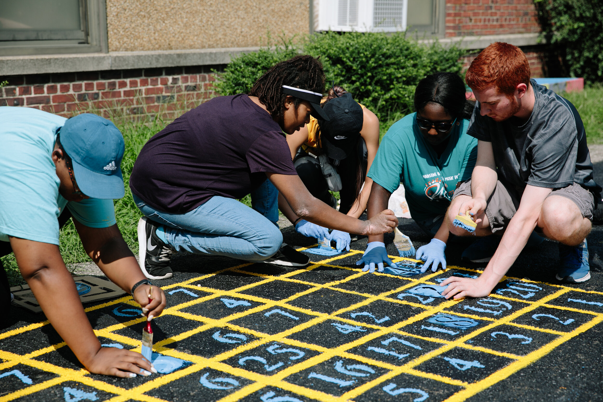 Adelphi students painting during a Garden Vines Project