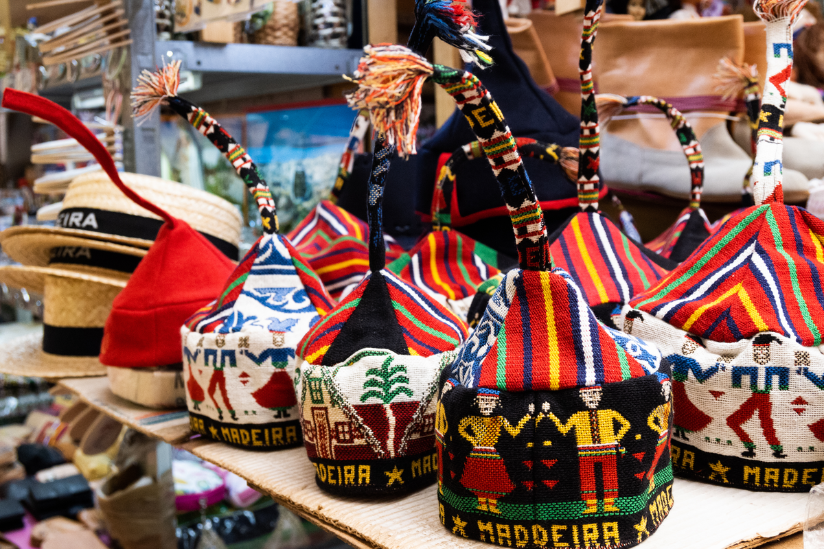 Colorful handmade woven hats with traditional patterns on display at a market stall.