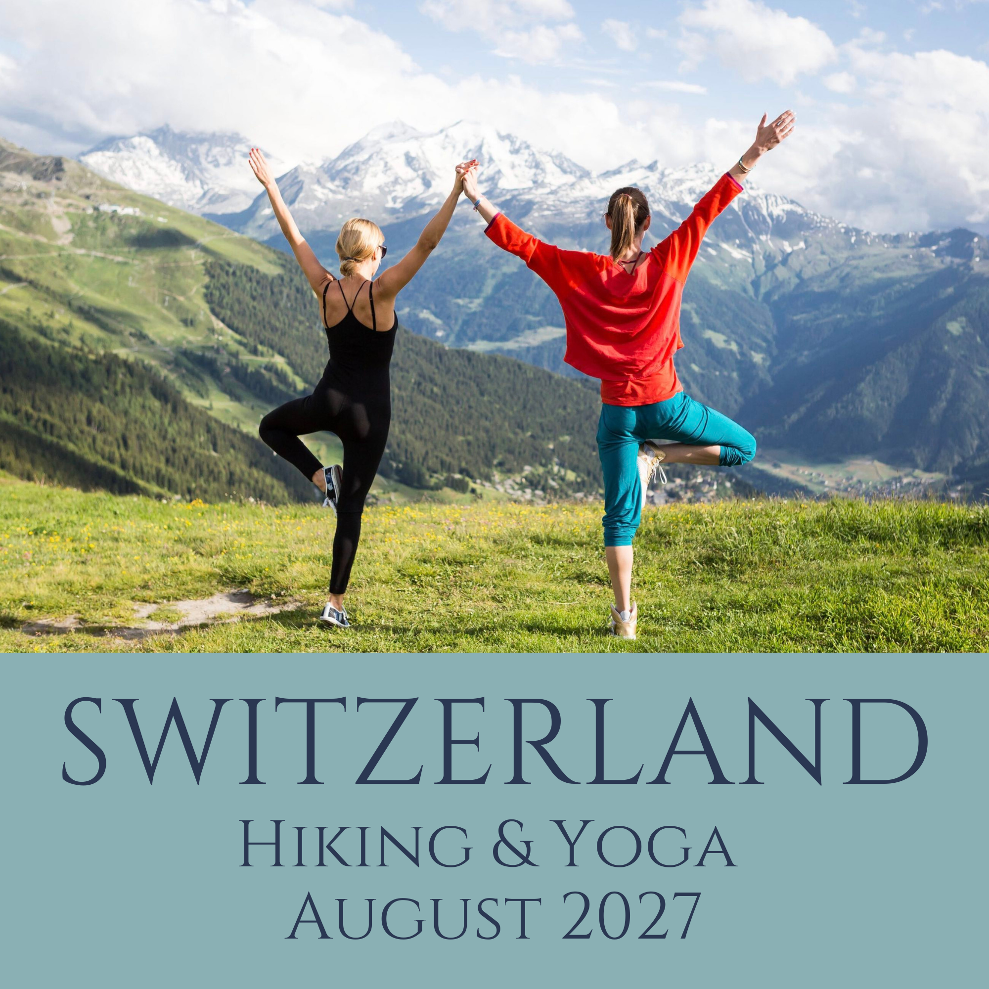 Two women practicing yoga outdoors on a grassy hillside with a mountain range in the background. One woman is wearing a black top and leggings, and the other is in a red top and blue yoga pants. They are holding hands and raising their arms in a yoga