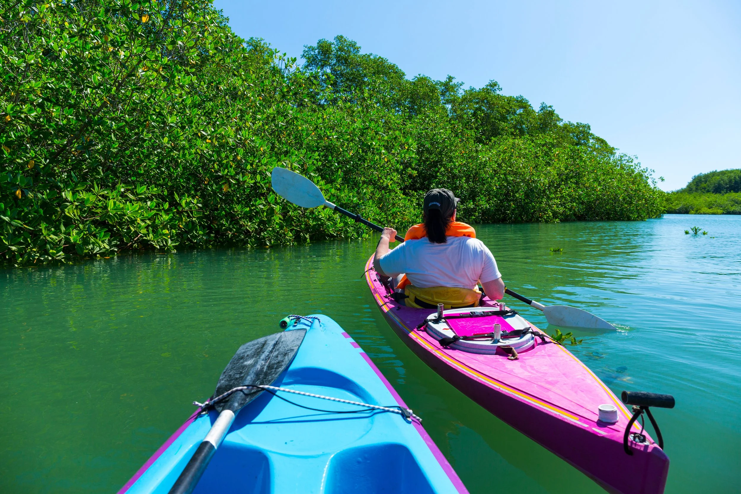 Colorful sea kayak at the Pacific coast of Costa Rica with the female girl paddling